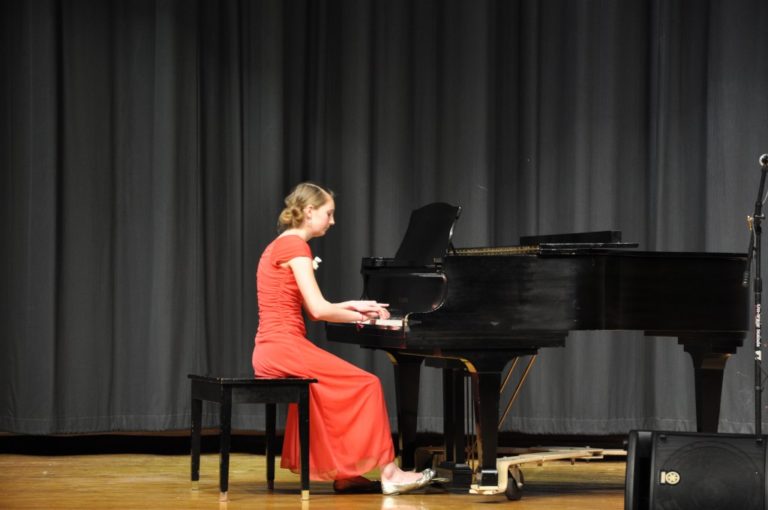 A young woman playing the piano in the Honors Concert at a Bowen Young Musicians Festival