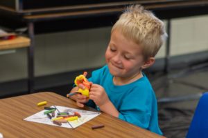 A young boy enjoying a craft project at MAT Camp