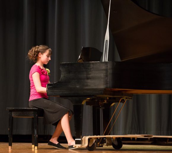 A young women playing the piano for the Honors Concert at the Bowen Young Musicians Festival
